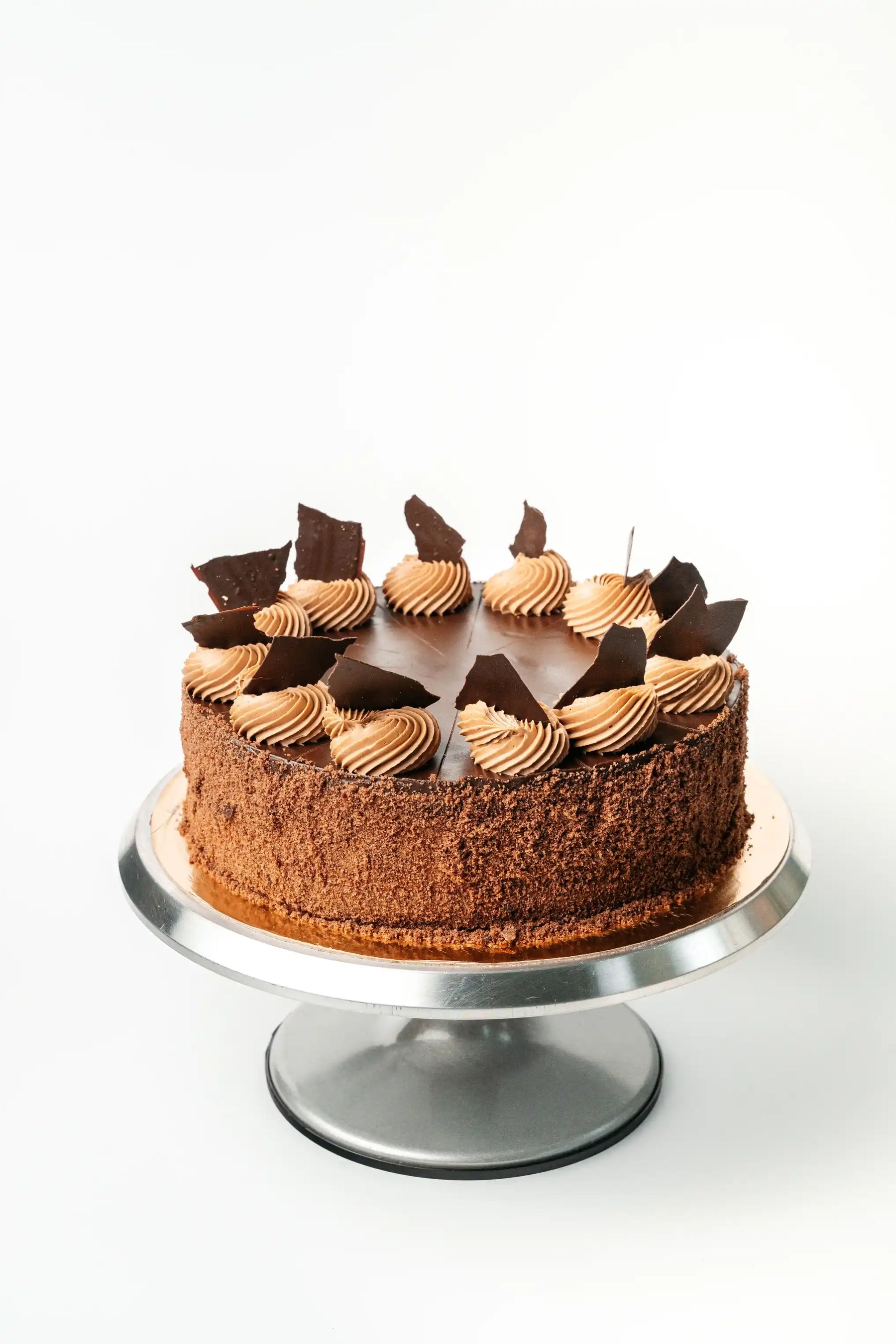 assorted whole cakes displayed on cake stand with chocolate decoration and layered textures, selection of celebration cakes from bakery in Wrocław