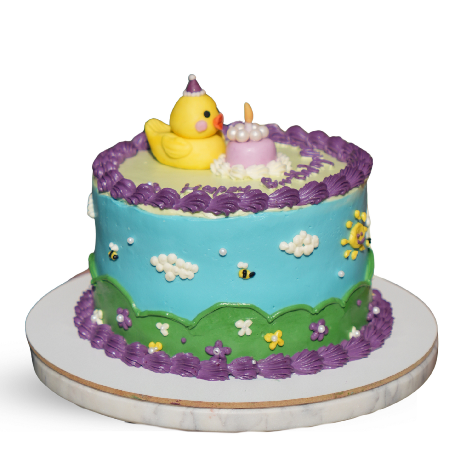 A close-up view in image.png shows a birthday cake decorated with blue cream frosting, bees, a yellow duck figurine, and a purple border. Dessert Boutique.