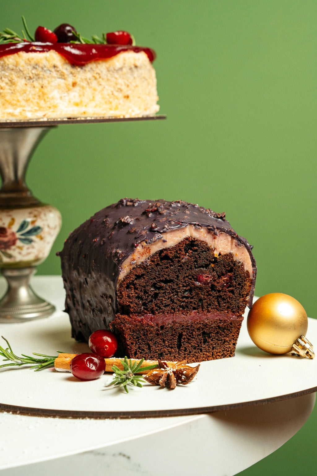 gingerbread loaf cake with chocolate glaze, cocoa crumb coating and cranberry layer on festive table setting