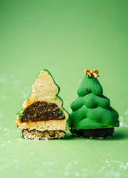 christmas tree–shaped mousse dessert with green velvet finish, layered fig filling and financier base on green background