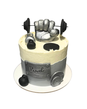 Gym themed cake decorated with a large metallic silver fist holding a barbell, kettlebells, and weight plates, personalized Pawel by Dessert Boutique