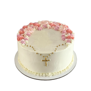 White cake with a gold bead cross design and a colorful border of pink, peach, and cream piped flowers.