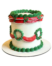 Lambeth-style holiday cake with green piped ruffles, red garlands and wreath decorations on round cake board