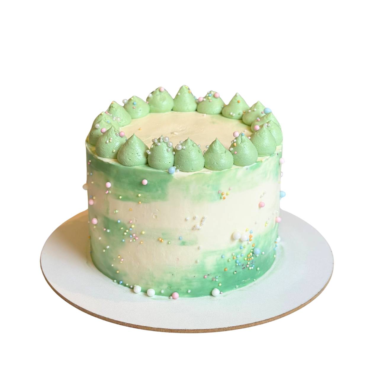 Minimalist cream cake with green watercolor frosting swirls and colorful sugar pearls by Dessert Boutique.