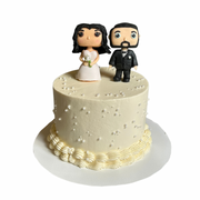 Smooth white wedding cake sprinkled with edible pearls and topped with custom bride and groom figurines. Available in Wroclaw for weddings.