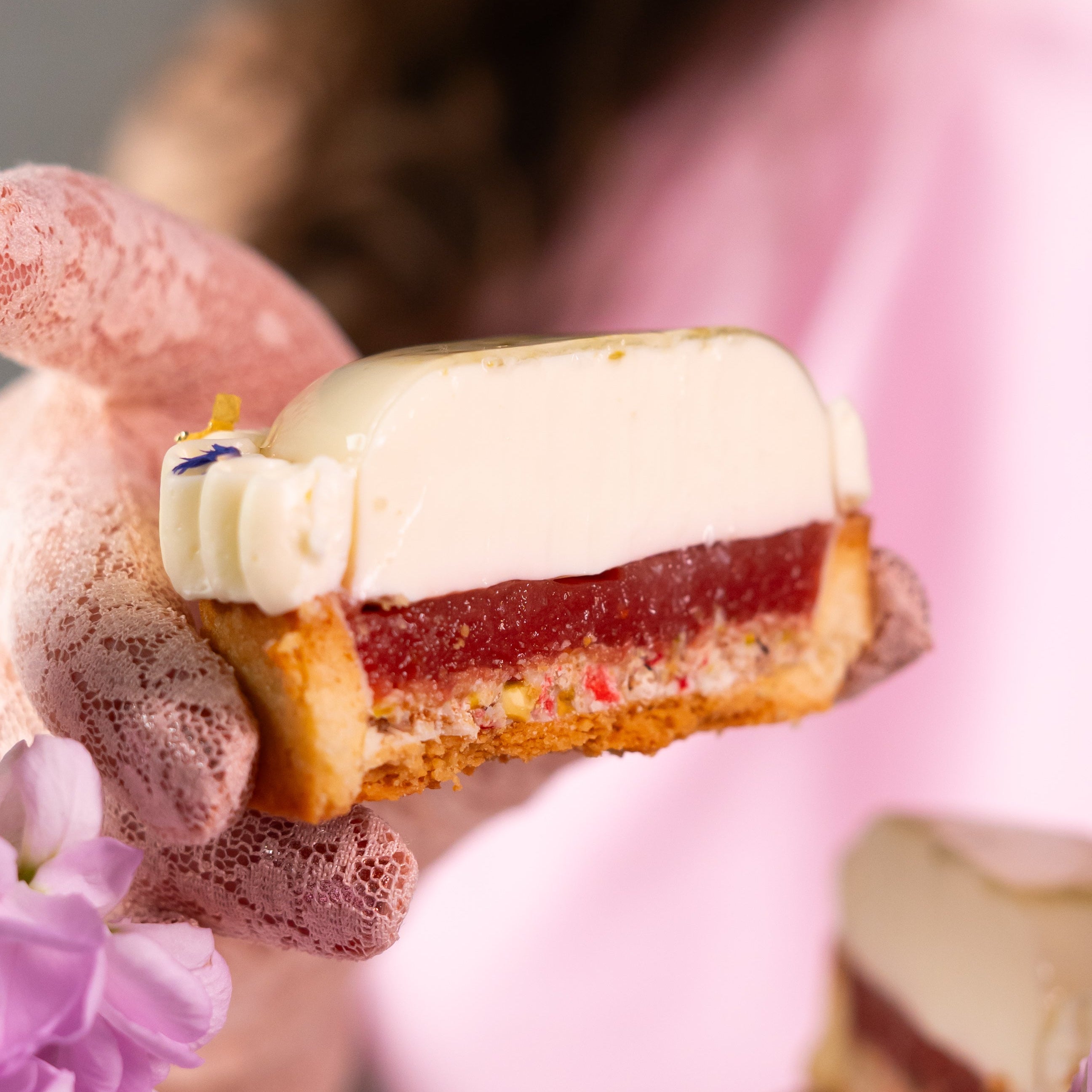 Strawberry basil tart with cream topping and fresh fruit decoration held in hands with lace gloves