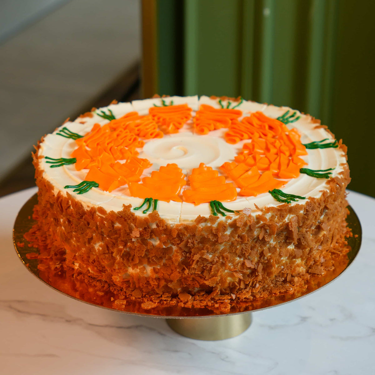 A stunning whole carrot cake elegantly decorated with creamy frosting, perfect for cozy autumn gatherings and celebrations