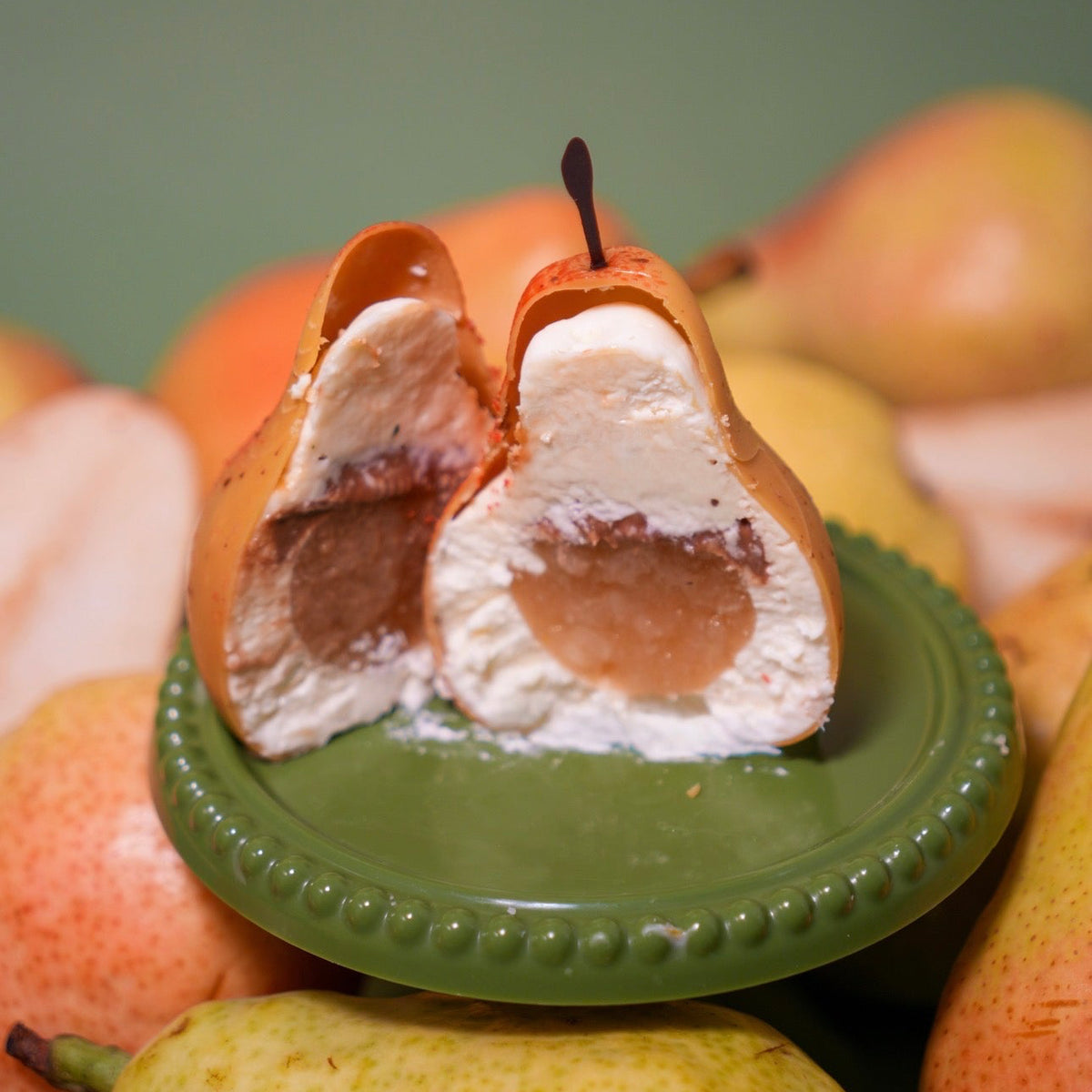 Cross section of a pear dessert showing lemon verbena white chocolate ganache, brandy caramel, and pear compote filling